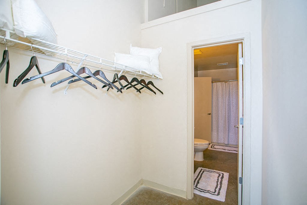 a room with a closet and several pairs of shoes hanging on the wall