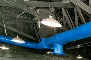a gym with cardio machines and weights in a building with a blue ceiling