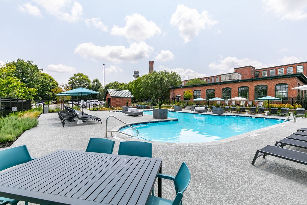 a swimming pool with a picnic table and chairs