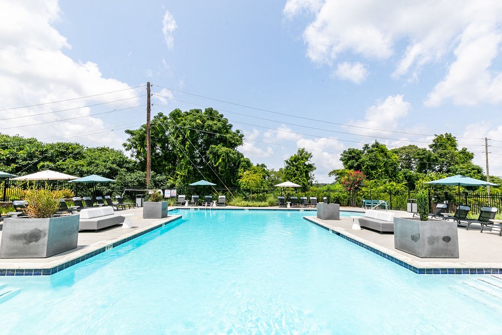 a swimming pool with lounge chairs and umbrellas at a hotel