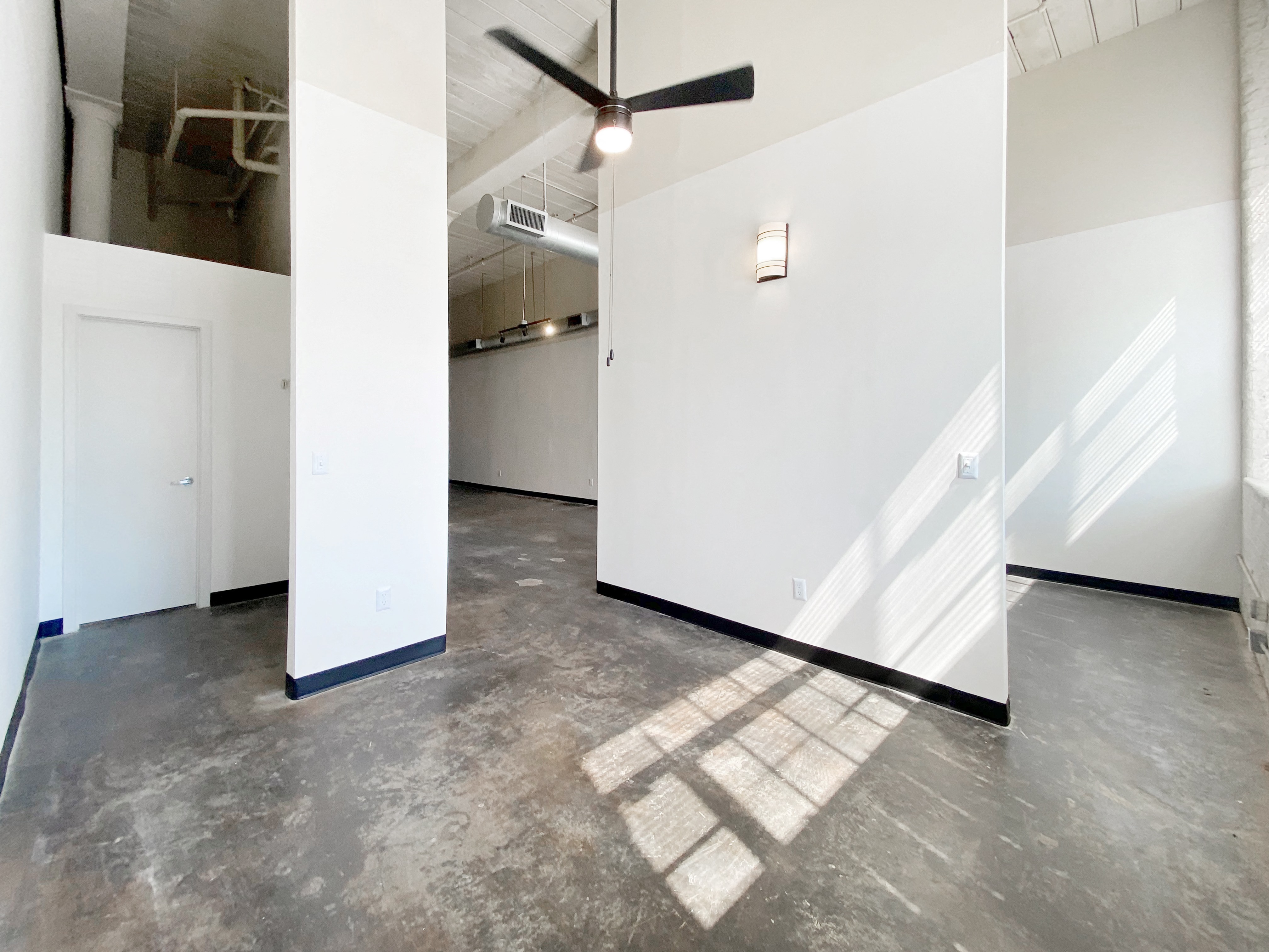 Main bedroom with ceiling fan, natural light, polished concrete floors and high ceilings