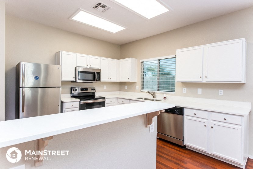 a large kitchen with white cabinets and stainless steel appliances