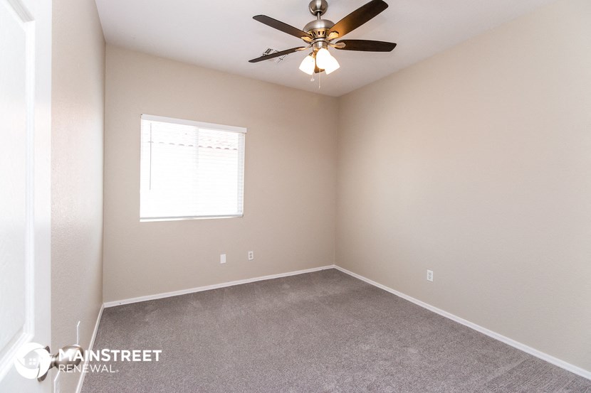 the upstairs bedroom has carpet and a ceiling fan