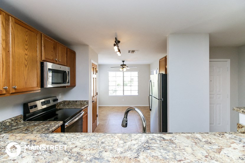 a kitchen with wooden cabinets and a granite counter top