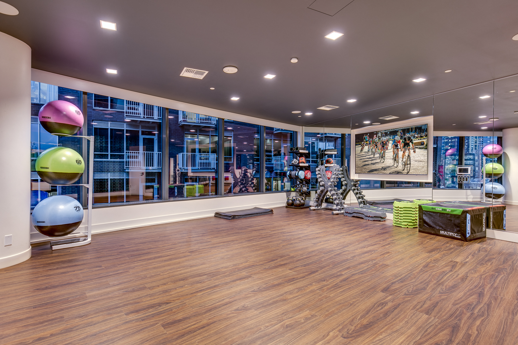 a gym with a wooden floor and large glass windows