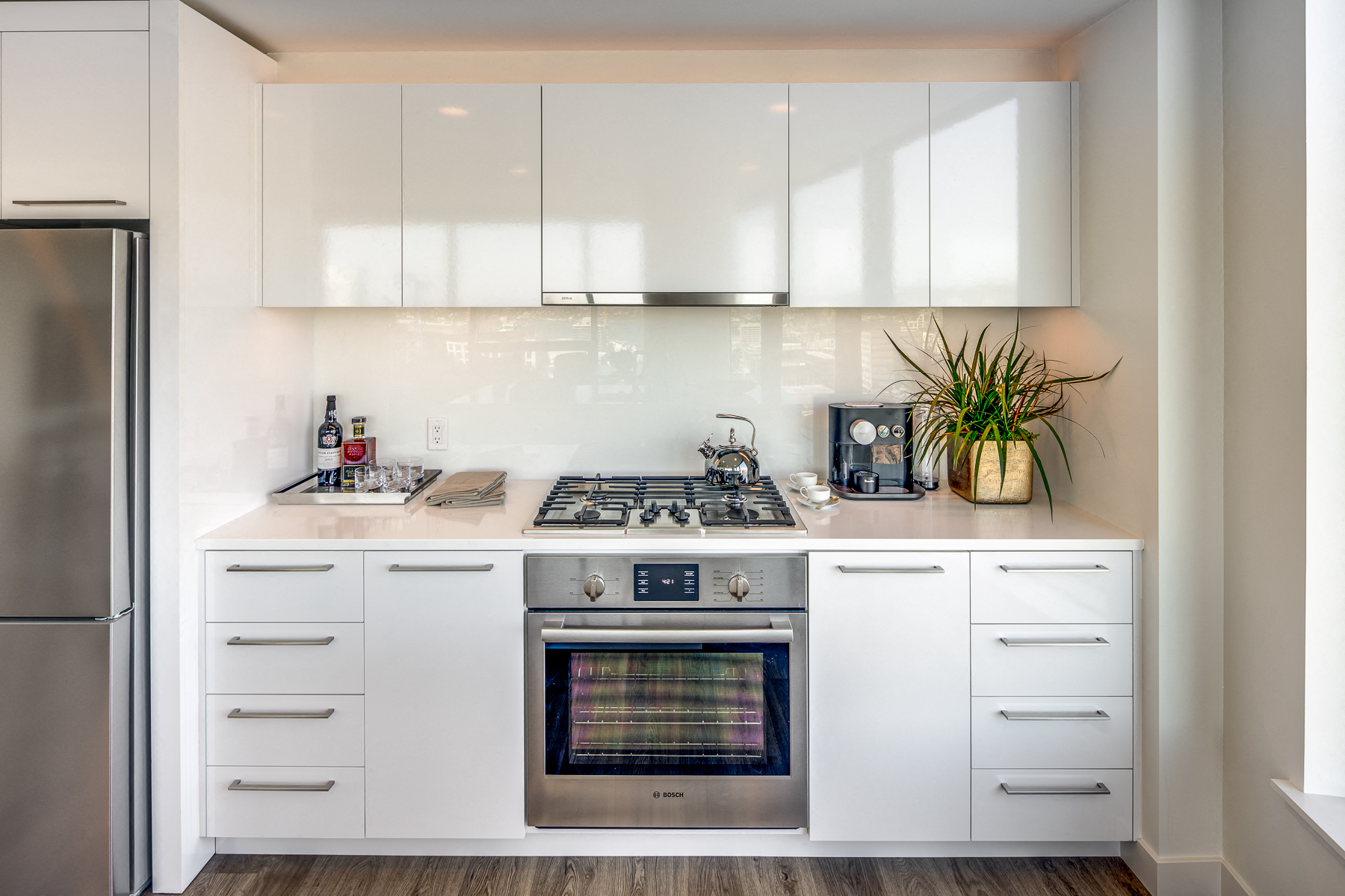 a white kitchen with stainless steel appliances and white cabinets