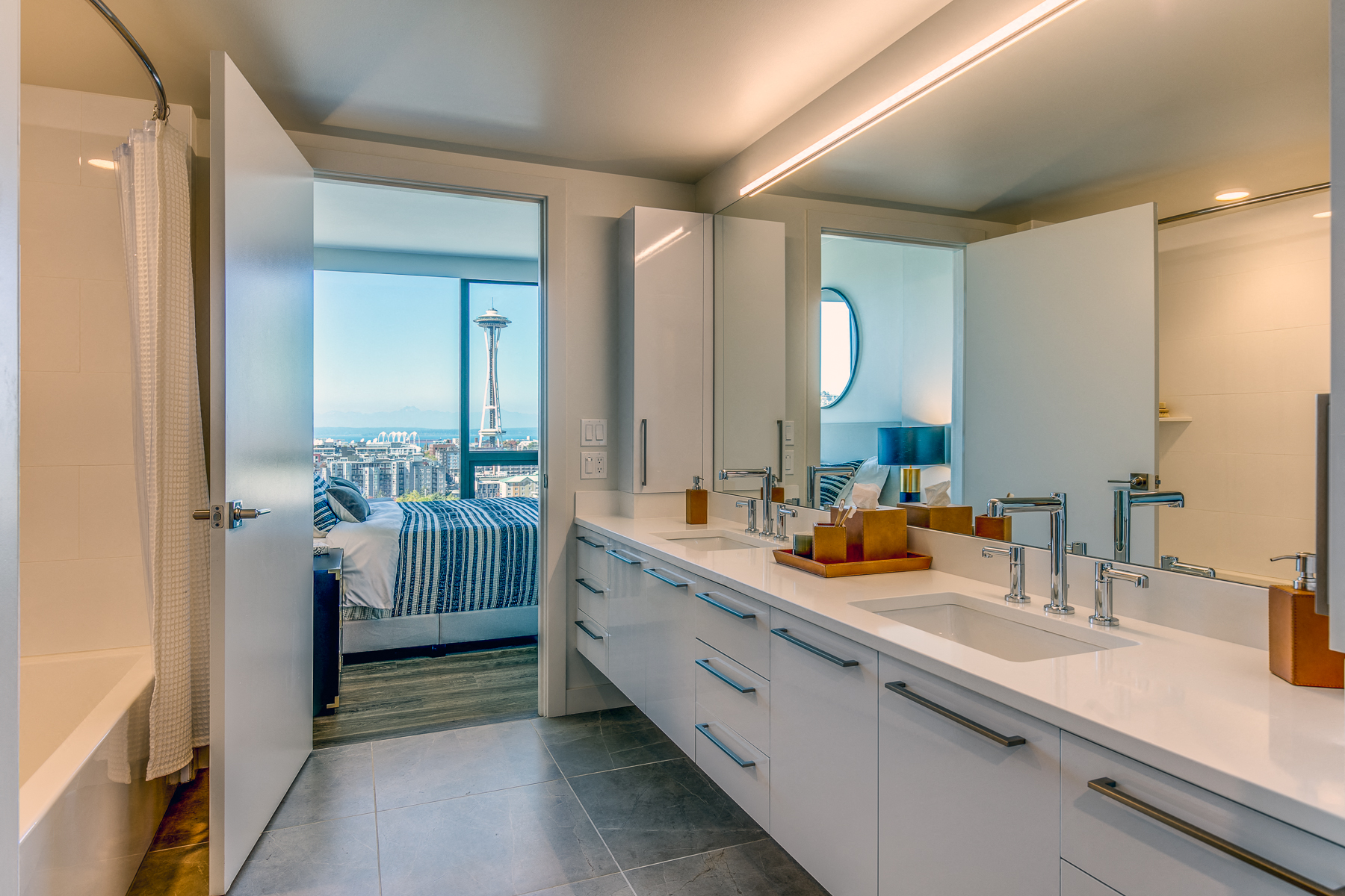 a bathroom with a view of a bedroom and a sink and a mirror