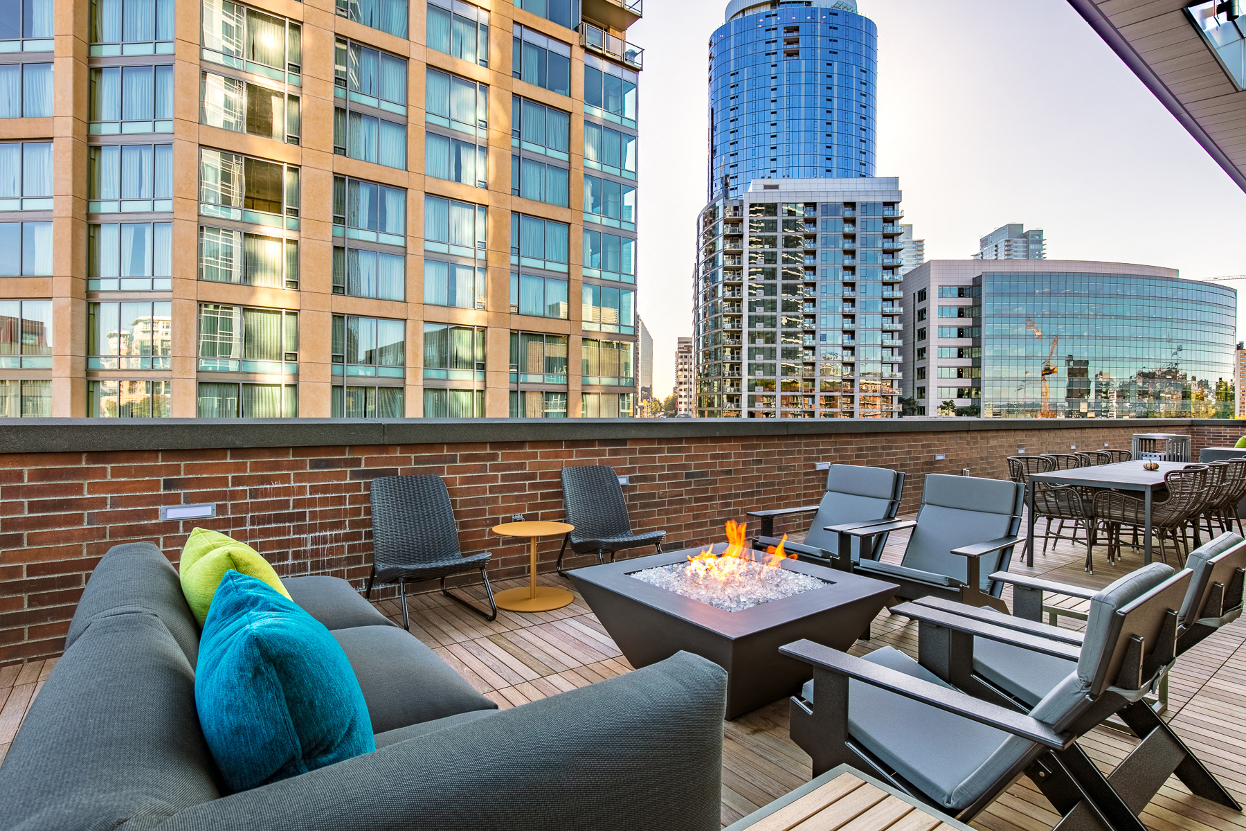 a rooftop patio with a couch and chairs and a fire pit
