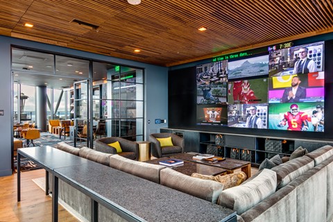a living room with couches and a large screen tv