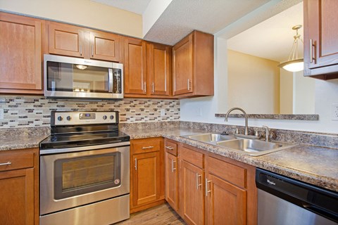 a kitchen with stainless steel appliances and wooden cabinets