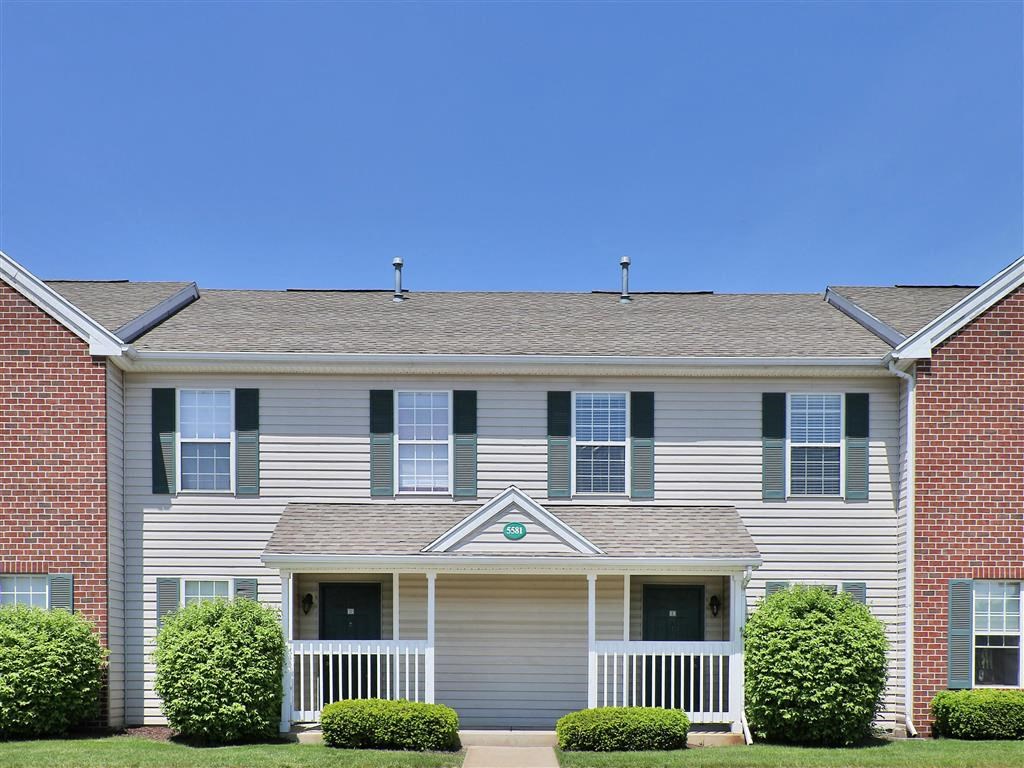 a white house with green shutters and a blue sky