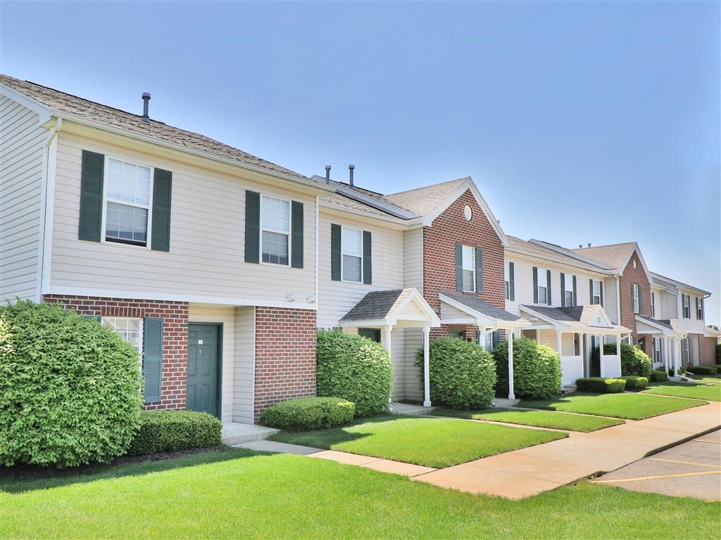 a row of houses with a sidewalk in front of them