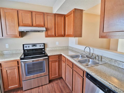 a kitchen with wooden cabinets and stainless steel appliances