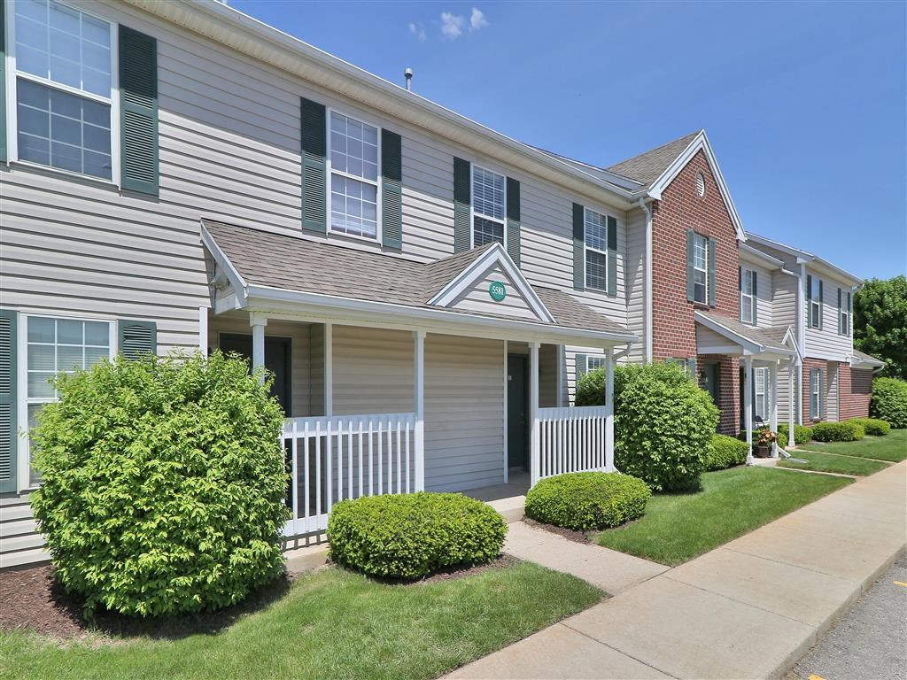 the front of an apartment building with a sidewalk
