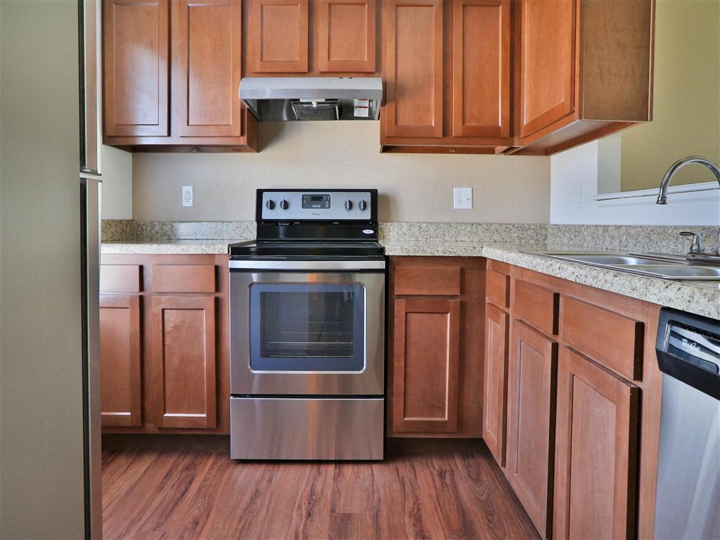 a kitchen with stainless steel appliances and wooden cabinets