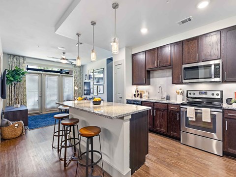 a kitchen with a large island with three stools