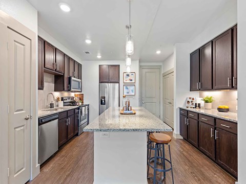 a kitchen with an island with a granite counter top