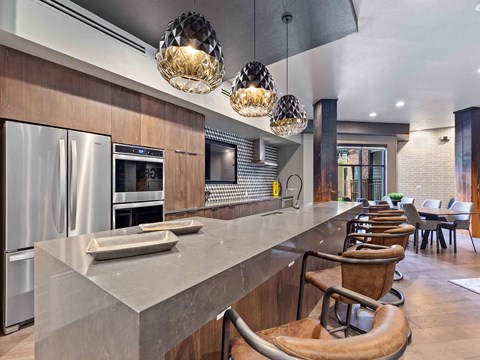 a large kitchen with a long counter and chairs