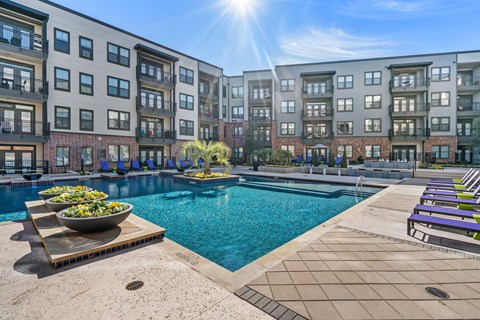 an outdoor swimming pool with an apartment building in the background