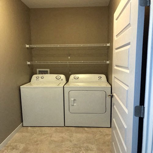 a closet with two washers and a dryer in it