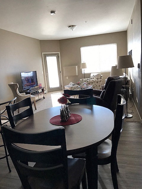 a living room and dining room with a table and chairs