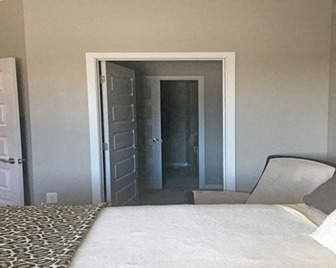 a bedroom with a bed and a chair and a door