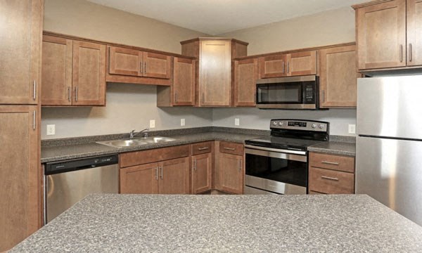 a kitchen with wooden cabinets and stainless steel appliances