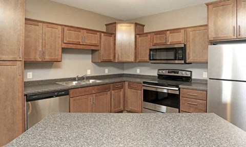 a kitchen with wooden cabinets and stainless steel appliances