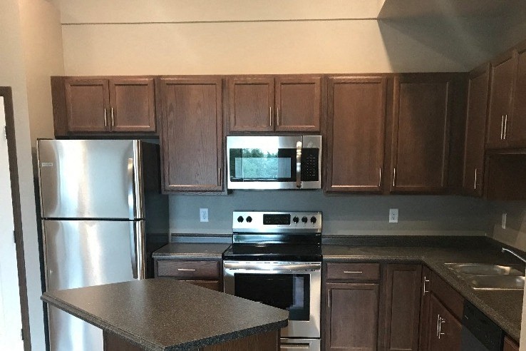 a kitchen with stainless steel appliances and wooden cabinets
