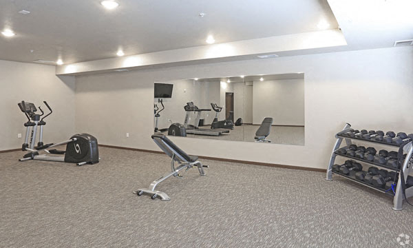 a gym with weights and a mirror on the wall