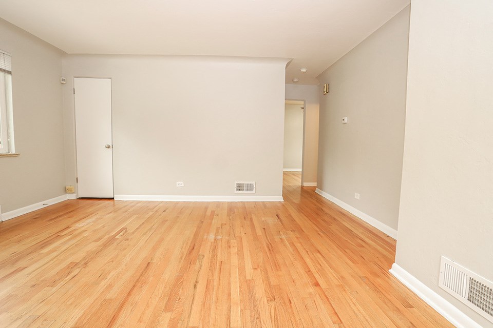 the living room and dining room of an empty house with wood floors