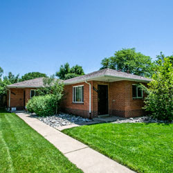 a brick house with a sidewalk and grass