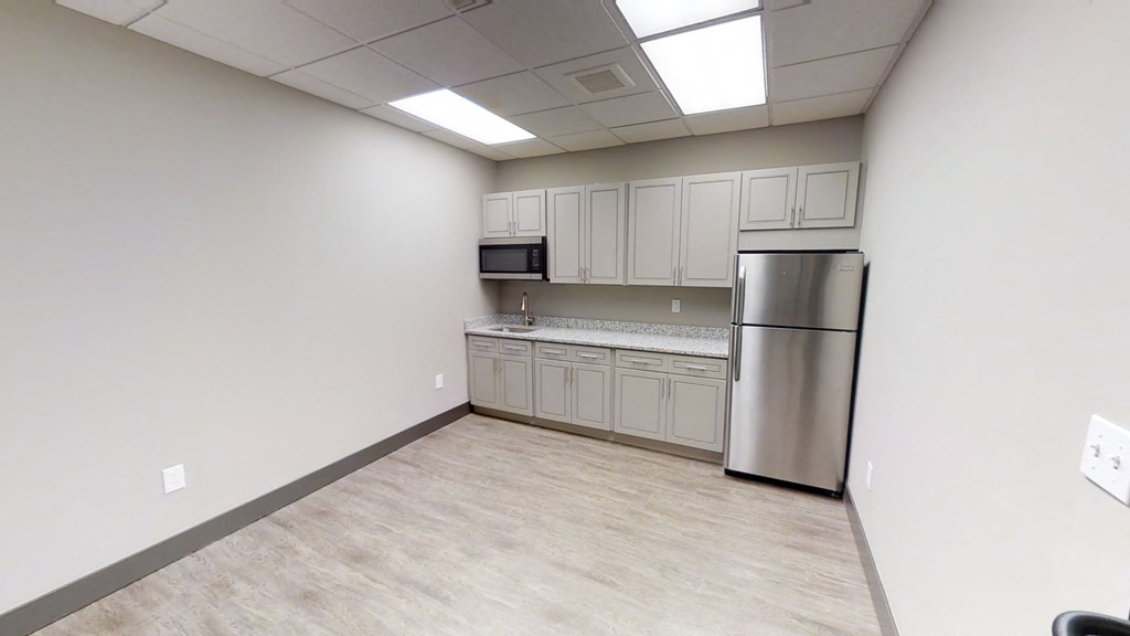 a kitchen with a stainless steel refrigerator and white cabinets