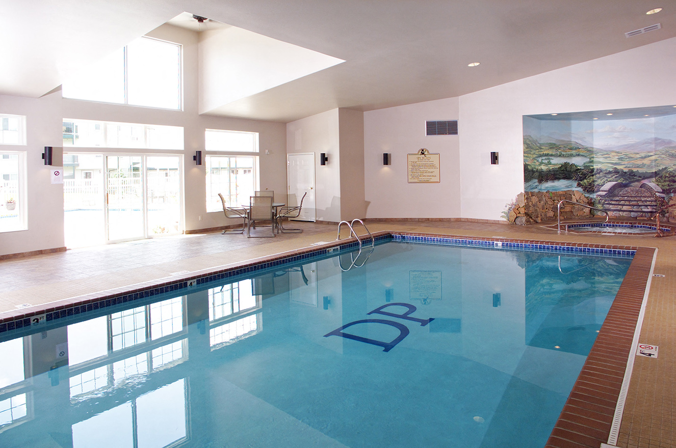 a swimming pool in a room with a large window