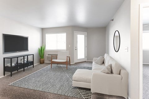 a living room with a white couch and a television