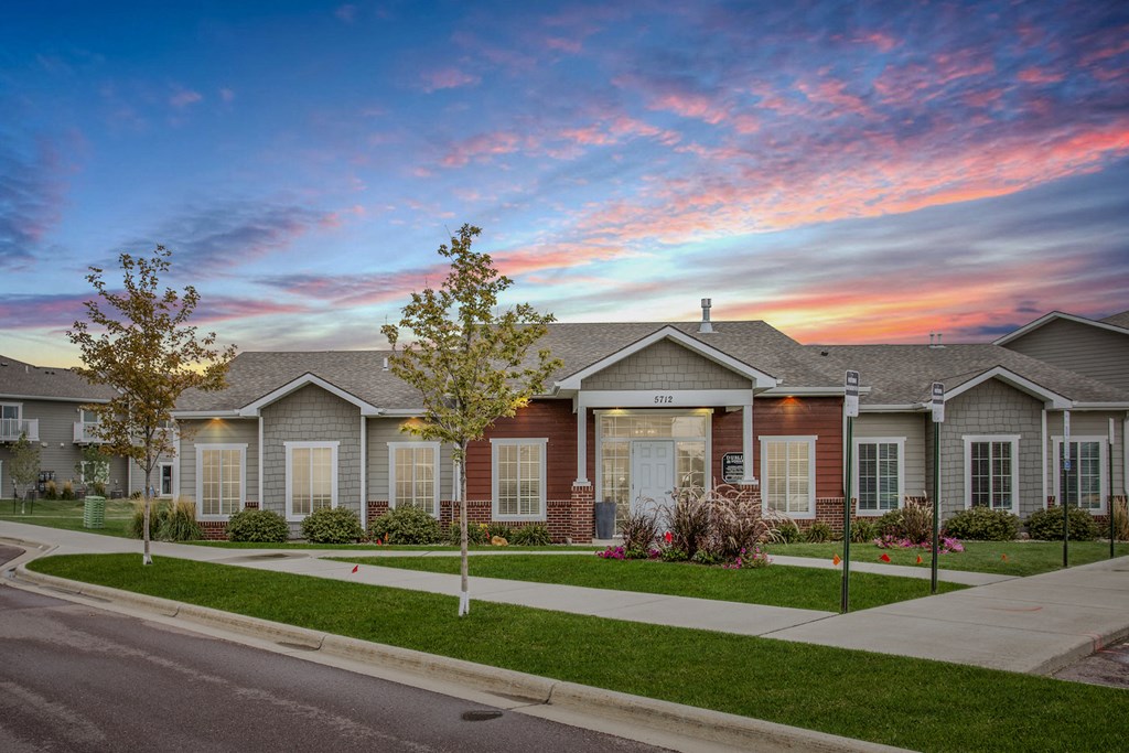 a house with a street in front of it and a sunset