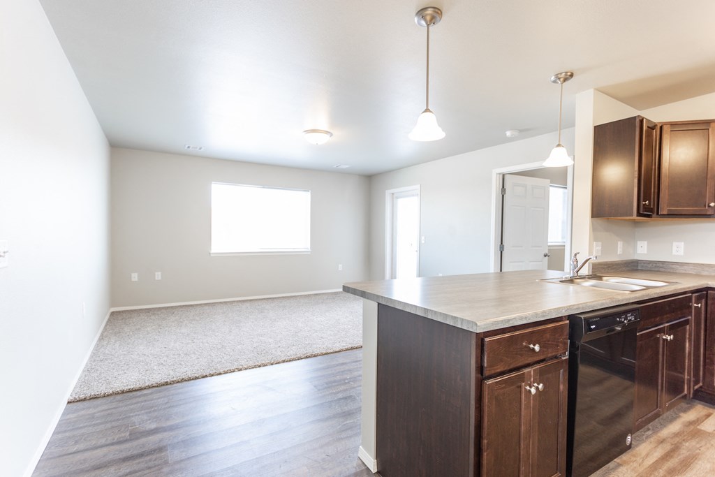 a kitchen and living room with wood floors and a large window