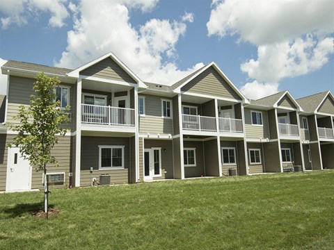 an exterior view of an apartment building on a hill