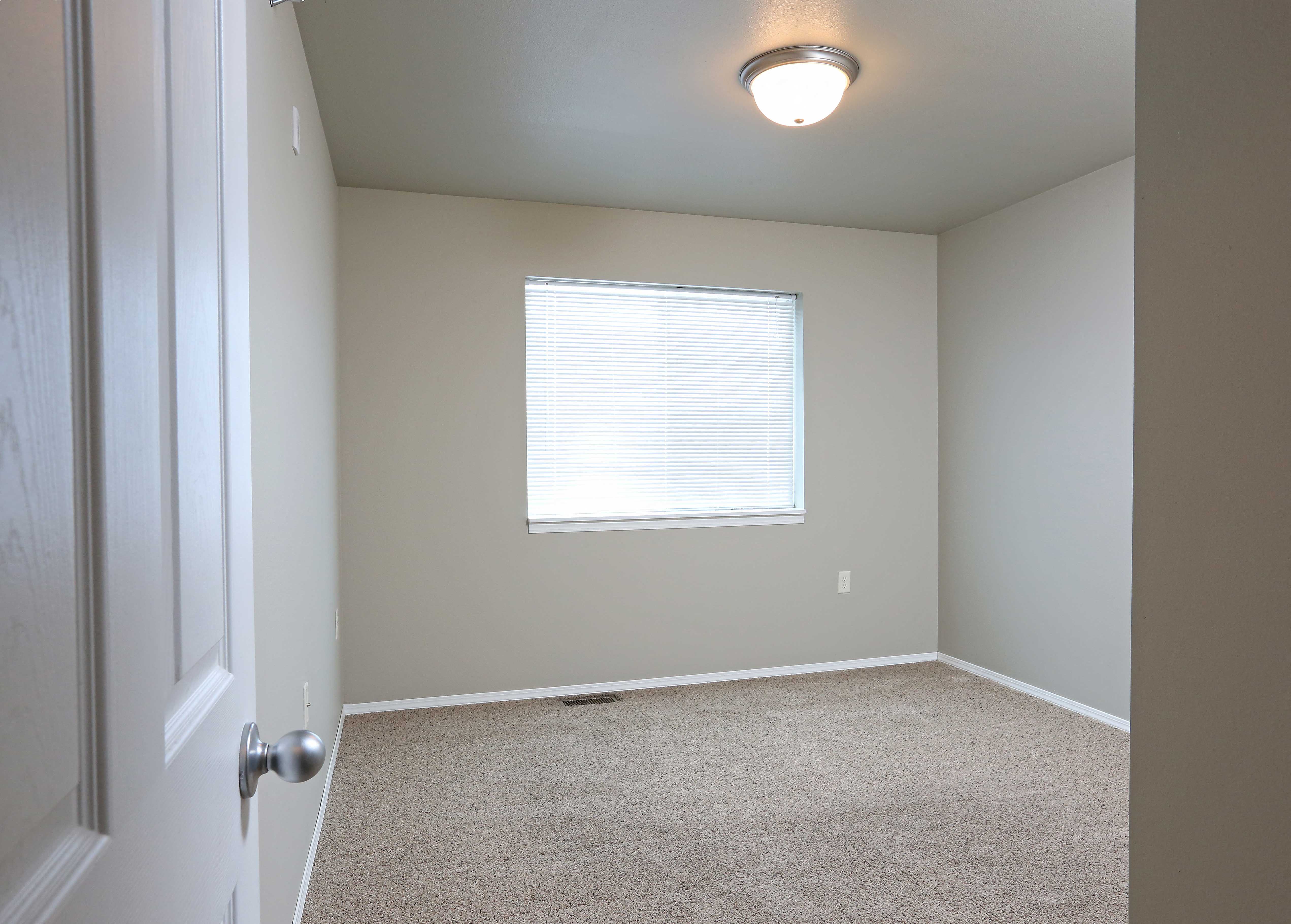 an empty room with a window and a door