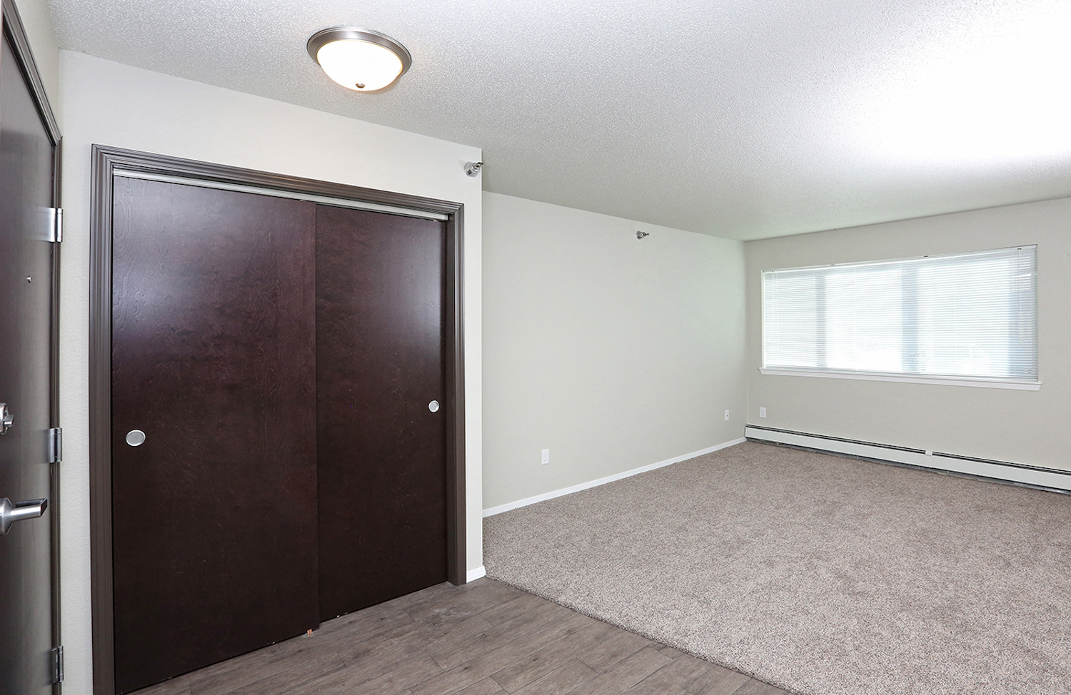 an empty bedroom with a closet and a window