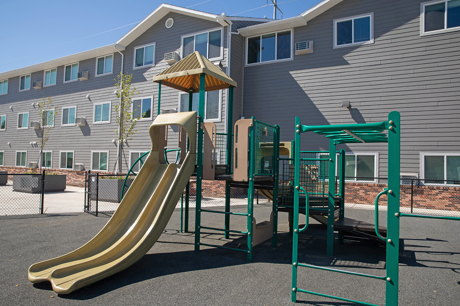 a playground with a slide in front of an apartment building