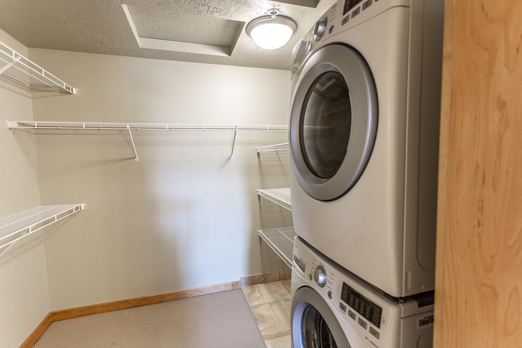an empty laundry room with a washer and dryer in it