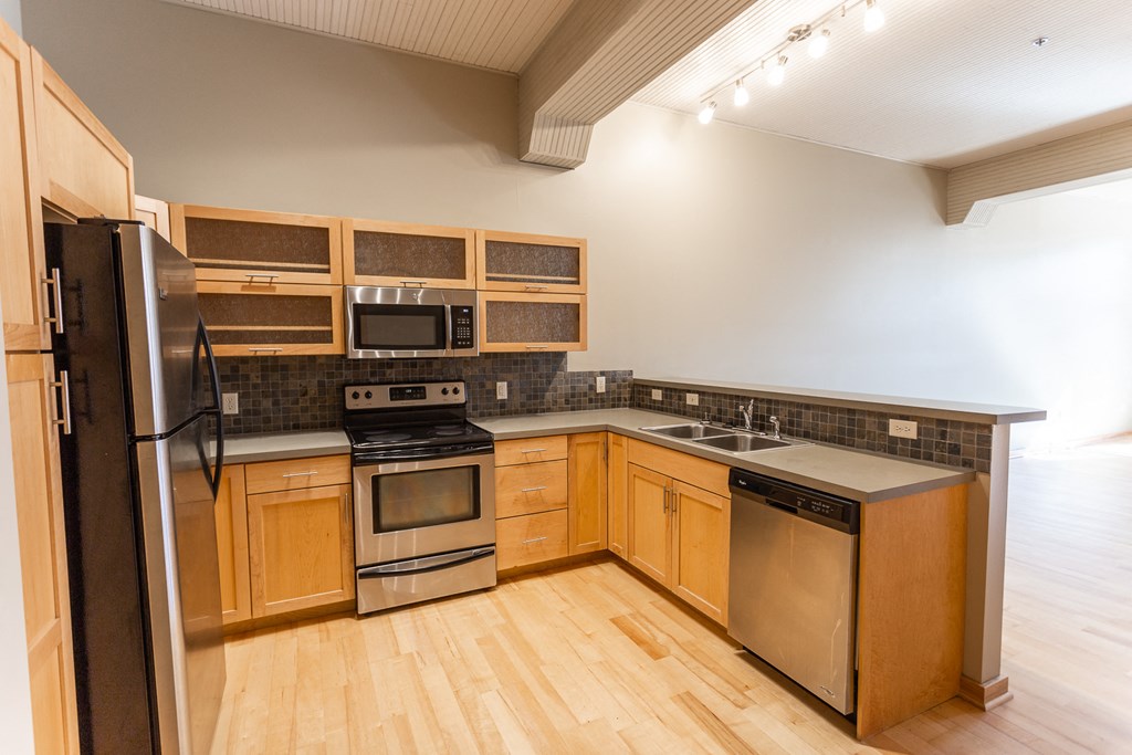 a kitchen with wooden cabinets and stainless steel appliances