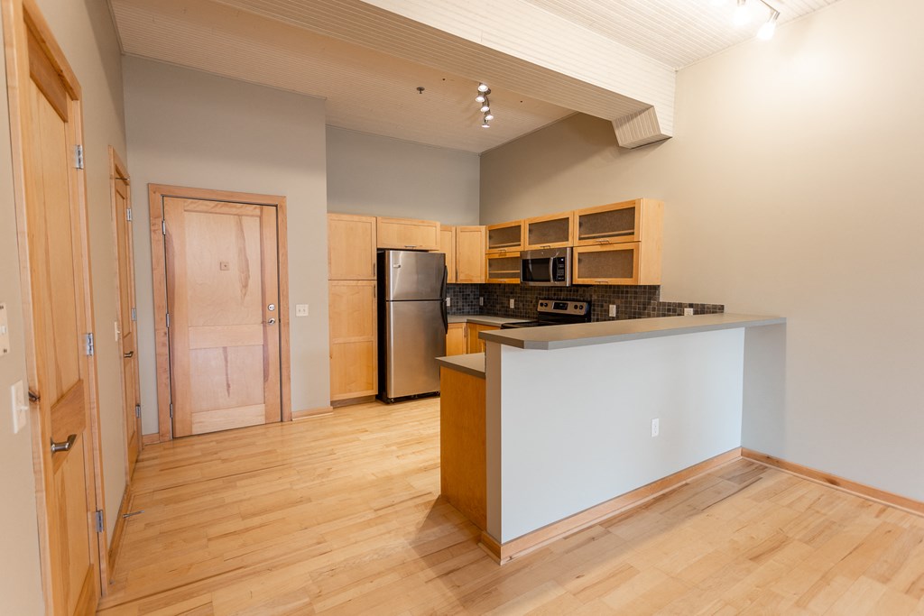 a kitchen with a island and a refrigerator and a door