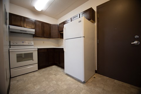 a kitchen with a refrigerator and a stove and a door