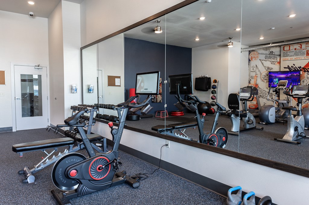 a home gym with exercise equipment and mirrors