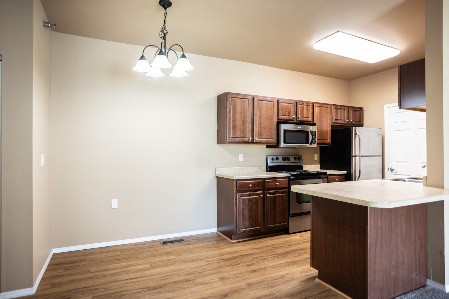 a kitchen with wooden cabinets and a white counter top