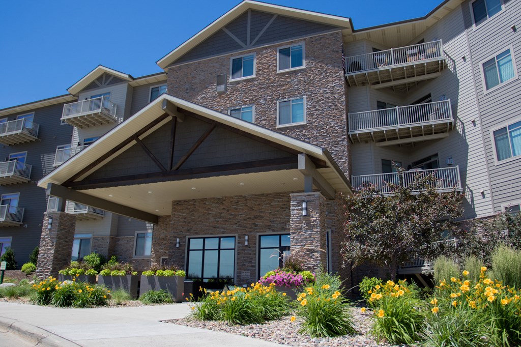 an apartment building with flowers in front of it