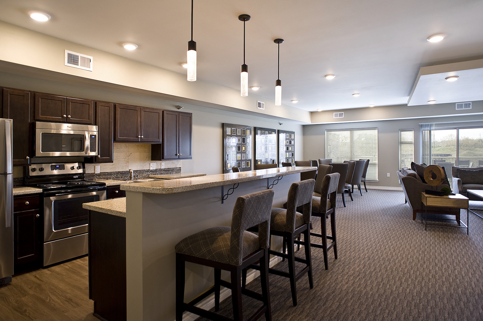 a large kitchen and dining room with a bar and chairs