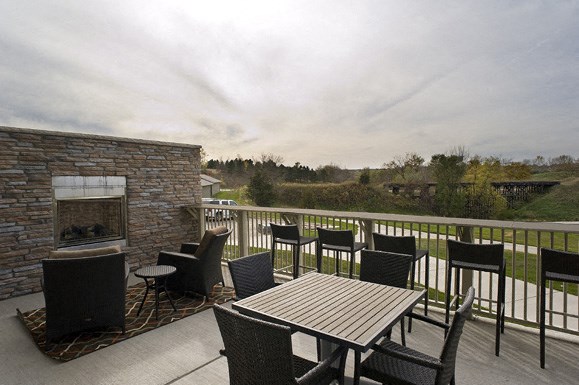 a patio with tables and chairs and a fireplace